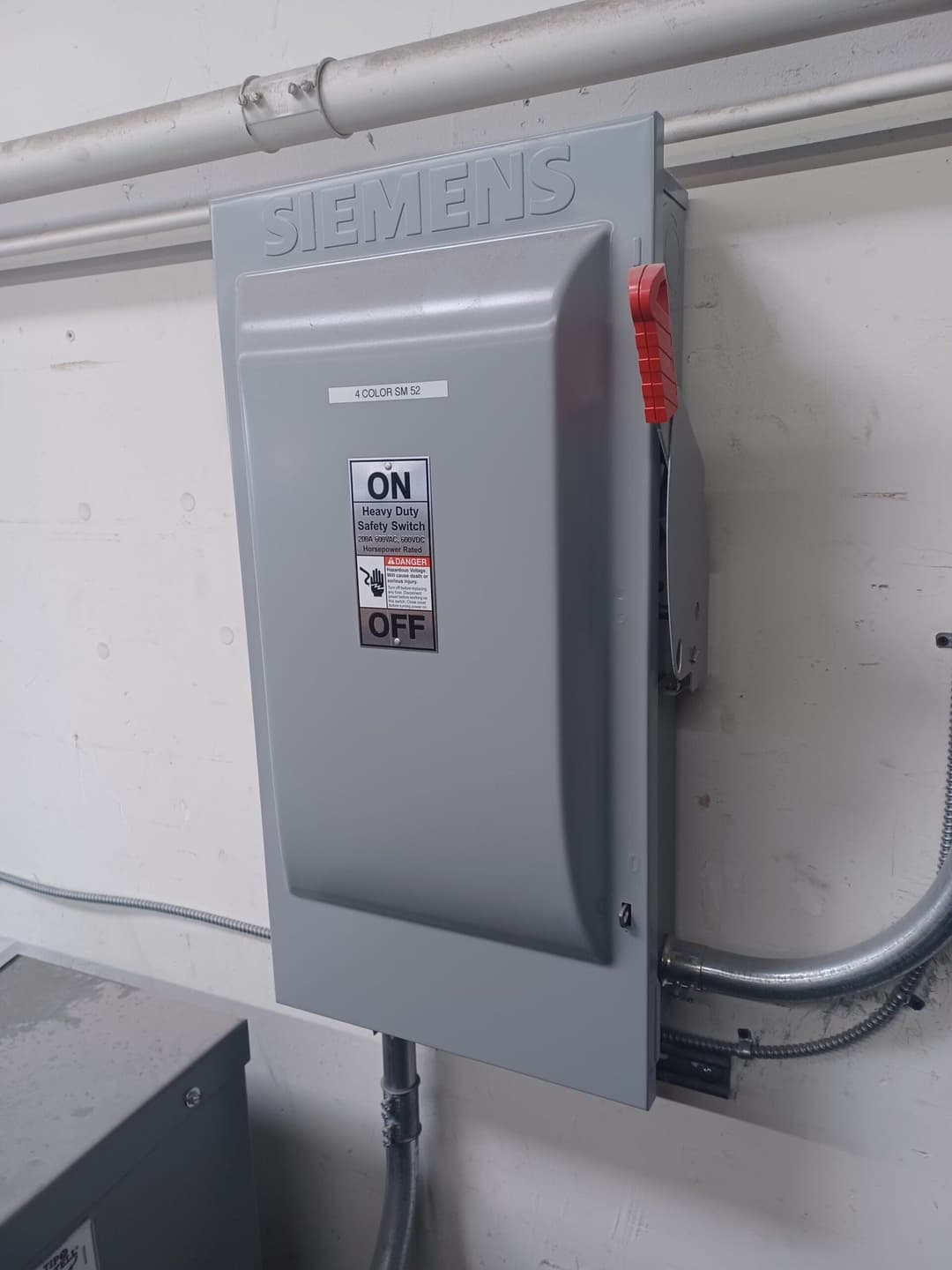 Siemens heavy duty safety disconnect switch mounted on a wall with clear status indicator.
